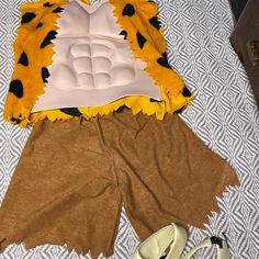 an animal costume laying on top of a bed next to shoes and a pair of high heels