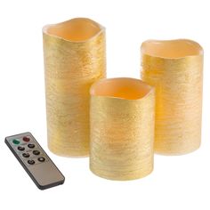 three yellow candles with remote control on white background