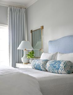 an instagram photo of a bed with blue and white pillows