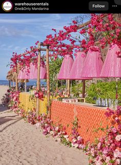 the beach is decorated with pink flowers and umbrellas