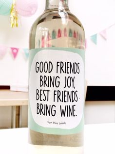 a bottle of wine sitting on top of a table next to a sign that says good friends bring joy, best friends bring wine