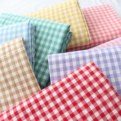 four different colored checkered sheets laying on top of each other in various sizes and colors