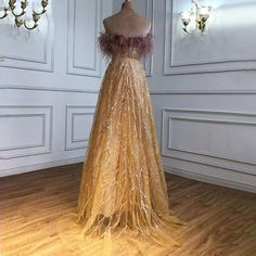 a dress on display in a room with white walls and chandelier hanging from the ceiling