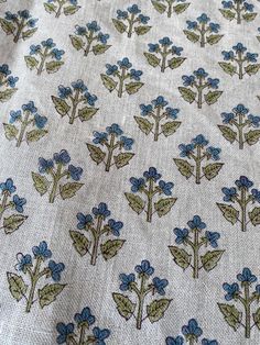 blue flowers on white fabric with green leaves