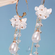 These long tassel dangle drop earrings features pearl like white flower and a long trail of artificial pearls and crystal drop earrings. These earrings make a big picture but light weight to wear, perfect wedding party earrings, bridal earrings, fashion earrings that can pair with your outfit to complete your fashion look. Materials: artificial pearls, resin, alloy, crystalFinish: gold color Jewelry Care: See more information about how to care for your jewelry here. Shipping Policy: Orders will Elegant Pearl Drop Tassel Earrings, Elegant Pearl Drop Tassel Earrings For Wedding, Elegant Pearl Drop Dangle Tassel Earrings, Elegant Pearl Drop Tassel Earrings For Party, Party Tassel Drop Earrings With Pearl Detail, Party Tassel Pearl Drop Earrings, Tassel Drop Earrings For Wedding, Wedding Tassel Earrings, Elegant Tassel Earrings With Dangling Beads For Wedding