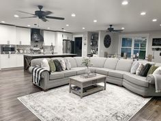 a living room filled with furniture and a large rug on top of a hard wood floor