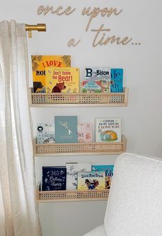 a white chair sitting in front of a book shelf filled with children's books