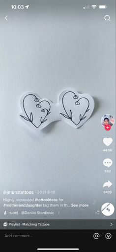 two heart shaped stickers on top of a white surface with the words love written in it