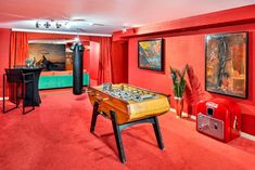 a game room with foo - pong tables and red carpeted flooring is shown