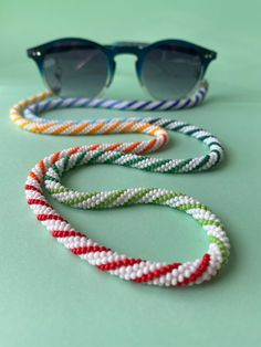 three pairs of sunglasses with different colored beads on the bottom and one pair in front