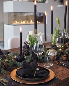 the table is set with candles and black napkins