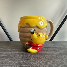 a winnie the pooh mug sitting on top of a table