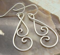 "These double spiral earrings are handmade by my daughter from sturdy sterling silver wire. They are smoothly curved and nicely polished, and are lightweight and comfortable to wear. We get tons of compliments on these. She's taken sterling silver wire and shaped it into a swirly double spiral, hand tempered them, smoothed the rough edges off and tumble polished them to make them springy and shiny. What I like about these is that the spirals touch each other, so your hair doesn't tend to get cau Diy Silver Earrings, Handmade Spiral Sterling Silver Wrap Earrings, Minimalist Sterling Silver Swirl Earrings, Adjustable Spiral Sterling Silver Wrap Earrings, Handmade Sterling Silver Earrings With A Modern Twist, Sterling Silver Hand Forged Wrap Earrings For Gifts, Hand Forged Sterling Silver Wrap Earrings For Gift, Hand Forged Sterling Silver Wrap Earrings As Gift, Hypoallergenic Sterling Silver Swirl Earrings