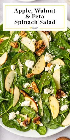 spinach salad with apples, walnuts and feta cheese in a white bowl