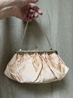 Mauve satin evening bag without a name and no indication it was ever used.  If interested I have a lovely hat that matches which is listed separately.   Perfect outside and inside. Bag is so cute that I don't think it has to be an exact color match and would work with beige tones as well as black outfits. Outer fabric is thick satin in a golden peach blush color.   Fabric is gathered into a filigree brass color frame in front with teeny clear crystal accents. Kissing locks on top. Chain strap tu Beige Feminine Evening Bag, Feminine Beige Evening Bag, Feminine Clutch Evening Bag For Events, Feminine Clutch For Evening Events, Feminine Beige Evening Bag For Formal Occasions, Feminine Beige Clutch For Evening, Gold Feminine Clutch For Formal Occasions, Gold Feminine Evening Bag For Formal Occasions, Feminine Cream Evening Bags