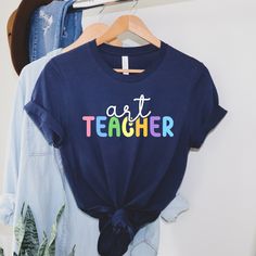 Art Teacher Tshirt - With over 39,000 sales and more than 5,000 reviews, we have experience in providing a t-shirt you will love. Our shirt options feel soft and comfortable made from cotton (heather colors also contain polyester).  - Soft t-shirts with quality shirt print - Fast customer service - We are here to help answer any questions! - Many different color and size options SIZING INFO Our unisex tees have a regular t-shirt fit. Width and length measurements for all sizes can be seen in the size chart images. If you prefer a looser fit we suggest 1 size up. Product measurements may vary up to 2 inches (5cm). The photos shown are examples. STANDARD UNISEX SHIRT - 100% cotton - Fabric weight: 4.5 oz/yd2 - Regular unisex fit PREMIUM UNISEX SHIRT - 100% combed and ring-spun cotton for sol Relaxed Fit T-shirt With Custom Artwork For Artistic Expression, Custom Artwork Short Sleeve T-shirt For Gift, Artsy Cotton T-shirt With Custom Print, Short Sleeve T-shirt With Custom Artwork As Gift, Artsy Summer T-shirt, Graphic Design Cotton T-shirt, Artistic T-shirt With Custom Artwork, Relaxed Fit, Casual Tops With Custom Artwork For Gift, Artistic Relaxed Fit T-shirt With Custom Artwork