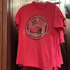 a red t - shirt hanging on a wooden door