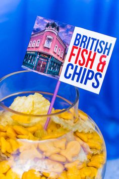 a glass bowl filled with yellow candies next to a sign that says british fish and chips