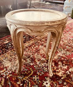 an antique coffee table sitting on top of a rug