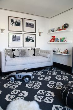 a living room filled with white furniture and pictures on the wall above it's couch