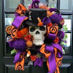 a halloween wreath with a skull wearing a top hat and purple, orange and black ribbons