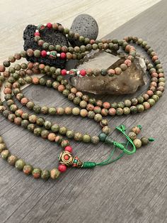 Unique and powerful Unakite Jasper stone Japa mala Necklace from Nepal. A unisex piece that will be perfect for your day by day outfits and will be easy to match any other accessories. If it fits right can be a bracelet also. This is also a Buddhist praying 108 beads mala, you can use this mala to stay grounded and meditate and also to stay in fashion at the same time. You can loosen up the beads to make it easy to meditate with the mala. The mala is 42.5cm- 16.75 inch long A unique addition to Green Spiritual Mala With 108 Beads, Adjustable Green Spiritual Mala, Green Adjustable Spiritual Mala, Spiritual Multicolor Jasper Necklaces, Multicolor Jasper Spiritual Necklace, Spiritual Green Hand Wrapped Beads, Bohemian Hand Wrapped Mala With Round Beads, Spiritual Jasper Jewelry For Meditation, Handmade Spiritual Jasper Beaded Necklaces