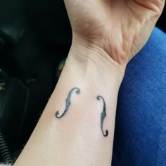 a person with a tattoo on their wrist has a small black moustache in it