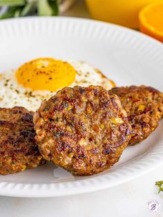 two meat patties with an egg on top are served on a white paper plate