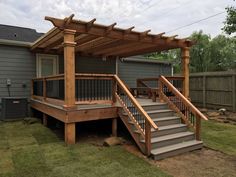 a wooden deck with steps leading up to it and a pergolan attached to the roof