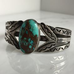 "Details: Lovely Native American Sand Cast Turquoise and Silver Bracelet. The turquoise is a deep blue with silver veins, and measures 1\" x 3/4\", and the face of the bracelet measures 1 3/4\" high. This piece has a nice weight to it. Please ask all necessary questions prior to placing an order. Measurements: The bracelet is a cuff, and can be adjusted to fit small to medium wrists. The interior measures 2 1/2 across, and the interior measures 5 1/2 inches.. Condition: The overall all condition Classic Adjustable Turquoise Cuff Bracelet, Turquoise Cuff Bracelet With Polished Finish, Unique Blue Oval Cuff Bracelet, Southwestern Engraved Blue Cuff Bracelet, Classic Turquoise Cuff Bracelet Gift, Adjustable Turquoise Cuff Bracelet With Polished Finish, Adjustable Turquoise Polished Cuff Bracelet, Blue Turquoise Oval Bracelet, Unique Turquoise Oval Cuff Bracelet