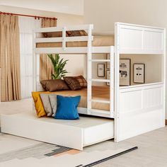 a white bunk bed sitting in the middle of a living room