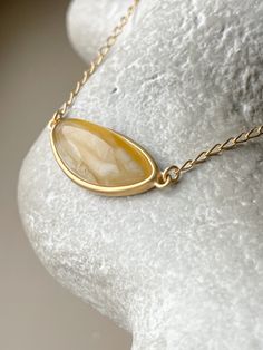 Embrace the captivating allure of the Baltic sea with this chic, elliptical amber pendant. Each piece showcases a pristine slice of natural Baltic amber, renowned for its warmth and depth, encased in a sophisticated gold-plated sterling silver frame. This pendant is the essence of elegance, designed to add a touch of timeless sophistication to any outfit. Its unique organic patterns ensure that no two pendants are alike, offering you an exclusive piece of the earth's beauty. Sterling silver, amber, gold plated Chain length 15 - 16.5" Stone size 1,06" Weight 0,22 oz Organic Patterns, Organic Pattern, Amber Pendant, Gold Nugget, Amber Jewelry, Baltic Sea, Baltic Amber, Gold Plated Chains, Silver Frame