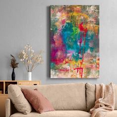 an abstract painting hangs on the wall above a couch in a room with gray walls