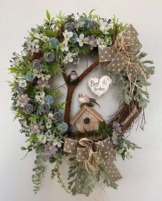 a wreath with birds and flowers hanging on the wall