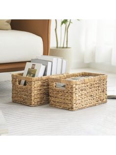 two wicker baskets sitting on top of a bed next to a book shelf with books in it