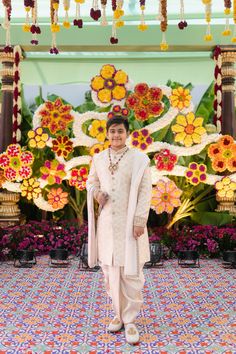 a woman standing in front of colorful flowers