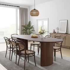 a dining room table with six chairs and a vase on the table next to it