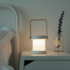 a white lamp sitting on top of a night stand