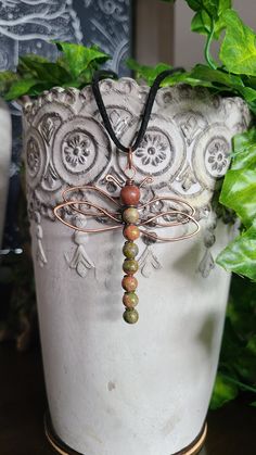 This adorable pendant features Unakite beads Wire Wrapped in **Antiqued Copper in a Dragonfly shape. **This piece has been aged with a Patina; however, Copper will still darken with age, so to revive the shine, please use the non-abrasive, reusable Jewelry polishing cloth provided.  Unakite is a pink and green metamorphic rock composed of pink orthoclase, green epidote, and colorless to milky quartz. It was first found in the United States in the Unaka mountain range of North Carolina from which it gets its name. Unakite exists in various shades of green and pink and is usually mottled in appearance. Unakite is said to be a stone of vision, opening the third eye and useful for scrying. It is also believed to be a stone of balance, grounding the self while bringing emotions and spirituality Edible Roots, Unakite Jewelry, Wire Wrapped Moon, Milky Quartz, Wire Jewellery, Beaded Crafts, Jewellery Ideas, Copper Pendant, Handmade Jewelry Gift