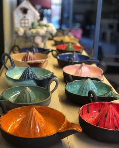 many different colored dishes are lined up on a table