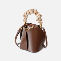 Make a sophisticated statement with the Brisa Ruched Handle Bucket Tote. Crafted with exquisite materials, this mini bag features an elegant ruched velvet handle and inner pouch for a subtle, yet luxurious look. Whether you’re heading to work or a night out, this effortless accessory is the perfect way to elevate your ensemble. Comes with two handles with or without ruched fabric & shoulder strap. Limited Quantities - Hurry! SIZE: W15 cm x H16 cm x D15 cm (W5.9" x H6.3" x D5.9") Gender: WOMEN It How To Clean Suede, Bucket Tote, Bucket Bags, Leather Floral, Luxury Diamonds, Leather Bucket Bag, Leather Satchel, Leather Fashion, Cow Leather