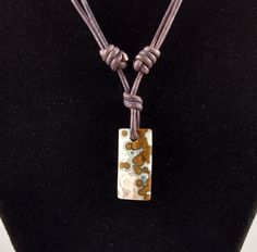 "Ocean Jasper pendant necklace. The pendant is approximately 1.0 inch in length and 0.5 inches wide on natural brown polished round leather. The necklace is adjustable from 16 inches to 32 inches by sliding the knots. The best known research on ocean jasper is by Dr. Werner Lieber. He theorized that it is a sphärolithischer Chalcedon (German, \"spherulitic or orbicular chalcedony\"). Ocean jasper only comes from one place in the world, northwestern Madagascar. It is found in the Analalava distri Adjustable Brown Necklaces With Sliding Knot, Brown Waxed Cord Jewelry For Everyday Use, Brown Waxed Cord Necklace For Gift, Adjustable Brown Necklace With Sliding Knot, Everyday Waxed Cord Brown Jewelry, Adjustable Brown Necklaces For Everyday Use, Everyday Brown Waxed Cord Jewelry, Adjustable Brown Necklace With Waxed Cord, Artisan Brown Jewelry With Sliding Knot