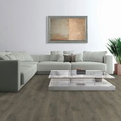 a living room with white couches and wooden flooring in it's center