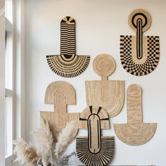 the wall is decorated with african art and decorative items in black, white, and tan colors