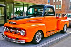 an orange truck is parked on the side of the street