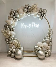 a mirror that has some silver balls and gold leaves on it with the words mr & mrs in front of it