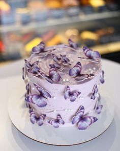 there is a cake with purple butterflies on it