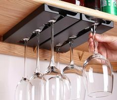 a person is holding wine glasses up to the ceiling