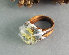 a wooden ring sitting on top of a table next to pine cones