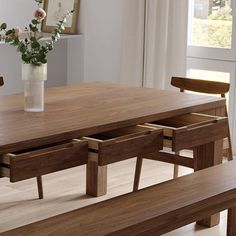 a wooden table with two benches next to it and a vase filled with flowers on top